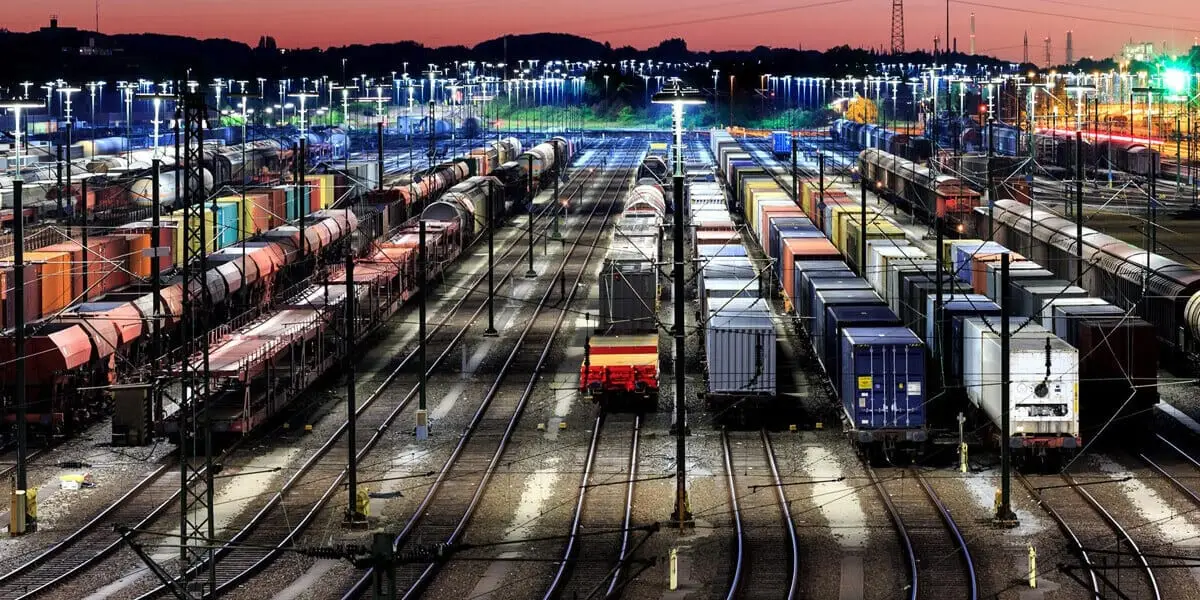Rail station at night housing rail freight with red sky