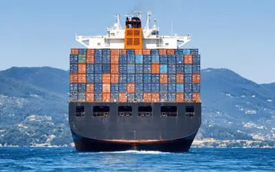 Ocean Freight Container Ship sailing off beautiful scenery
